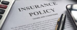 Image of Insurance Policy terms page with calculator and pen on it.