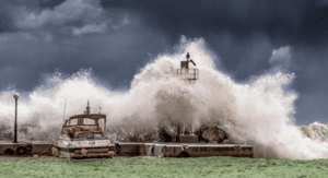 Boat insurance post image, large waves engulfing a dock and boat.